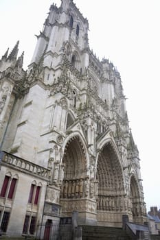 The intricate Gothic facade of Amiens Cathedral in France, featuring stunning architectural details, ornate carvings, and towering spires, showcasing historic grandeur.