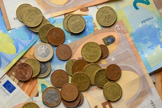 Various coins and colorful banknotes laid out on a table, showcasing the intricacies of currency design and value.