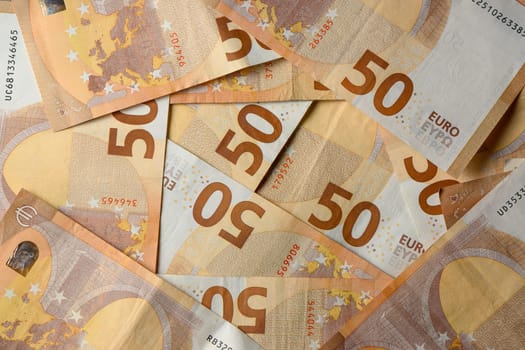 A collection of colorful 50 Euro banknotes arranged artistically, highlighting their detailed patterns and textures.