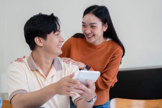 A couple reviews financial documents and bills together, showcasing teamwork and joy in managing their finances.