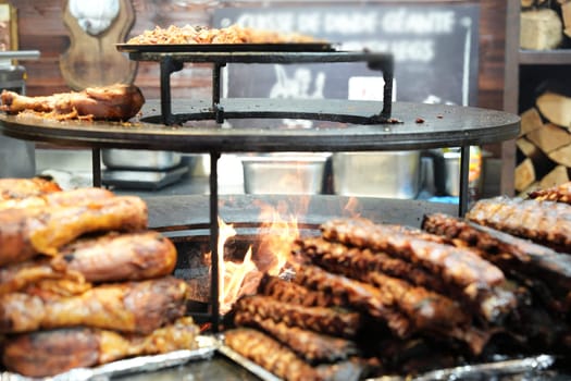A mouthwatering close-up of smoked ribs and roasted meat sizzling over an open flame barbecue, showcasing vibrant street food culture.