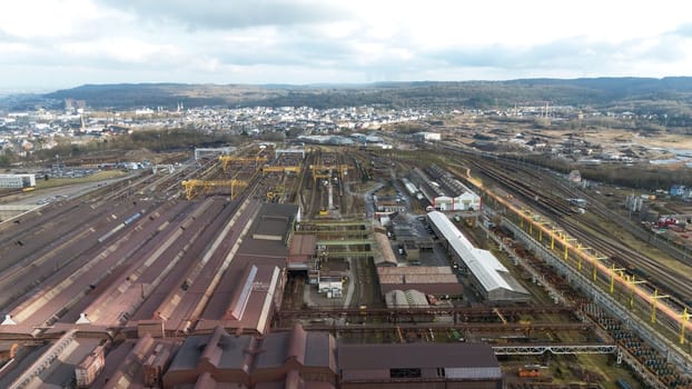 High-angle aerial view of a large steel production facility and railway infrastructure in Esch-sur-Alzette, Luxembourg, highlighting heavy industry, transportation, and urban surroundings.