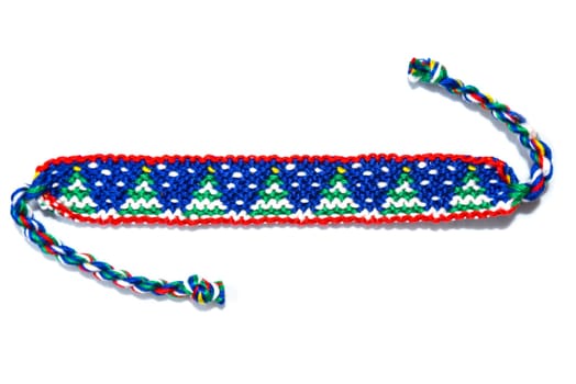 Woven friendship bracelet with Christmas pattern. Handmade of thread, isolated on white background. New Year DIY gift idea