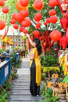Beautiful Vietnamese woman in traditional vietnamese dress near red lanterns in Tet  Lunar New Year