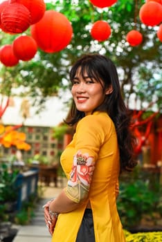 Beautiful Vietnamese woman in traditional vietnamese dress near red lanterns in Tet  Lunar New YearBeautiful Vietnamese woman in traditional vietnamese dress near red lanterns in Tet  Lunar New Year