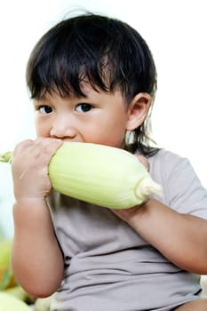 Close-up portrait of child eating fresh sweet corncob. Homegrown organic food. Vegan children nutrition
