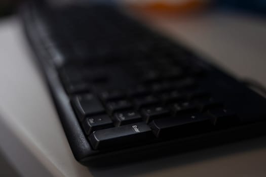 Black computer keyboard texture on the wooden table. 