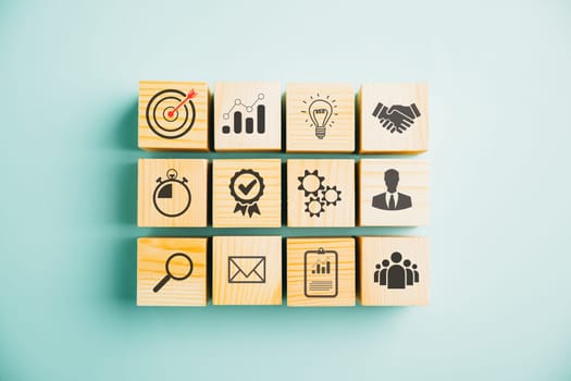 Wooden cube block step on a table with Action Plan, Goal, and Target icons. Success and business target concept. Project management and company strategy on a blue background.