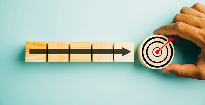 Wooden blocks with a Target icon on top, surrounded by upward arrows. Bar graph chart steps depict business growth on a blue background, embodying profit, investment, and economic improvement concepts