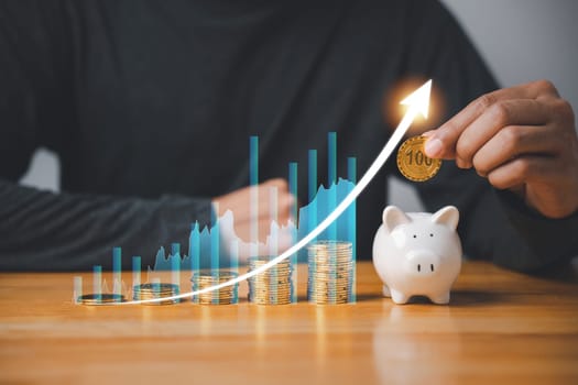 Financial planning for the future - businessman saving money in a pink piggy bank while monitoring stock market growth with a digital chart. Concept of investing, retirement, and wealth creation.