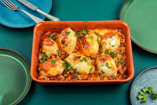 Delicious stuffed squid carcasses with salsa sauce in baking dish.