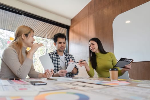 A diverse design team engaged in discussion and sharing feedback on design concepts in a contemporary workspace.
