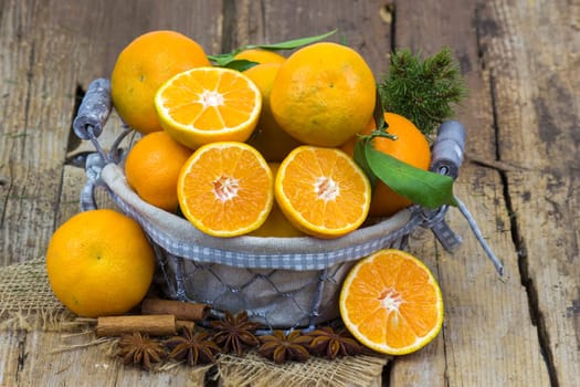 fresh tangerines in a basket on old wooden background