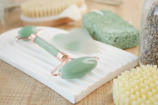Various skincare tools arranged neatly on a textured wooden surface.
