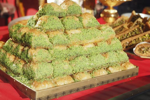A colorful baklava pyramid sits center stage at a festive gathering.