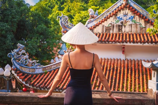 back of a woman tourist traveler at temple on the Buddhist pagoda in Vietnam. Travel and tourism in Asia