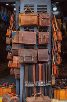 handmade leather bags, belts and accessories on counter in shop at a street market in Hoi An in Vietnam in Asia