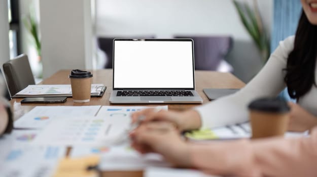 A team of women analyze financial documents and engage in a productive discussion during an office meeting, showcasing teamwork and collaboration.