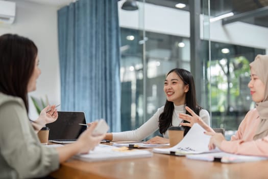 Engaged women present financial reports and share ideas in a collaborative office environment, highlighting teamwork and creativity.