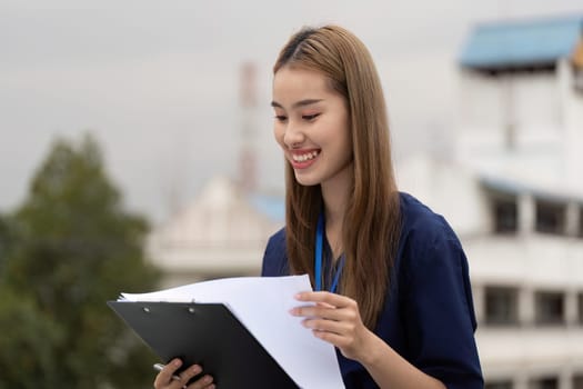 A cheerful female doctor examines documents outside, embodying a positive and professional demeanor.