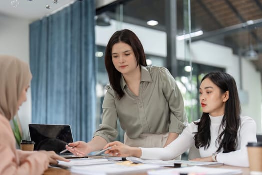 A team of office workers engages in a discussion about financial strategies, utilizing charts and documents for analysis.