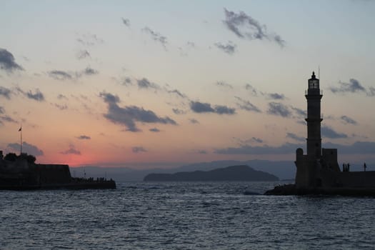 Lighthouse in old harbour of Chania at dawn Crete Greece at sunset