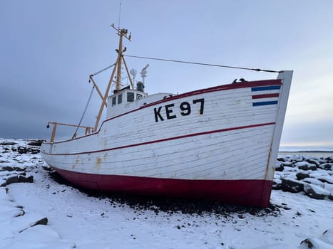 Keflavik, Iceland - January 27, 2025: The shipwreck fishing boat Baldur (1961) is aground on rocks on a sunny day. High quality photo