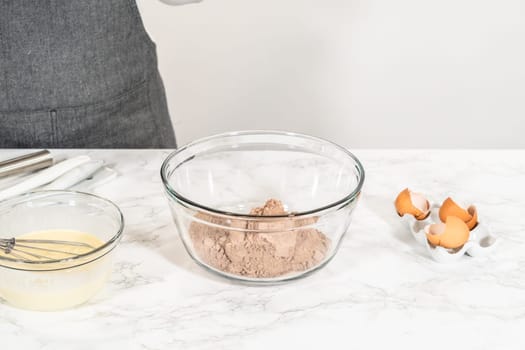 With a hand whisk, the ingredients are expertly mixed in a glass mixing bowl - creating this delectable Chocolate Bundt Cake.