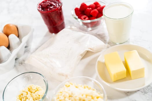 On the counter, the measured ingredients await - preparing for a delectable White Chocolate Raspberry Bundt Cake, promising a delightful and indulgent dessert.
