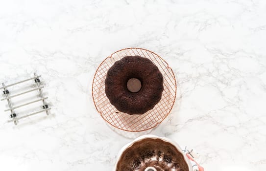 Flat lay. With precision, the Chocolate Bundt Cake is carefully removed from the pan - placed onto a round cooling rack, preparing it for a flawless presentation and delightful indulgence.