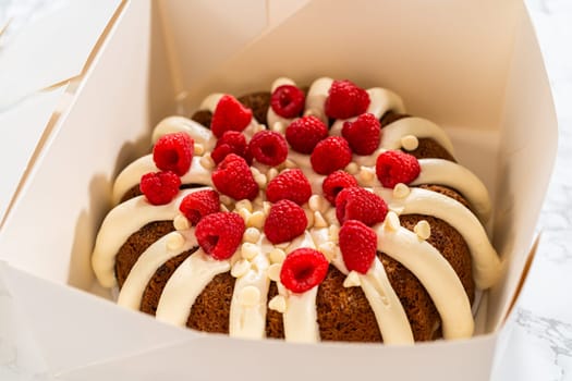 With care, the White Chocolate Raspberry Bundt Cake is packaged into a white paper box - ready for gifting to bring joy and indulgence to someone special.