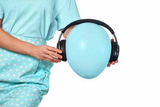Female hand holding blue balloon with headphones on white background