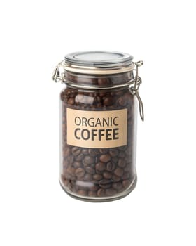 A glass jar filled with roasted coffee beans with a wooden lid and label. Perfect for coffee storage and brewing. Isolated on white background.