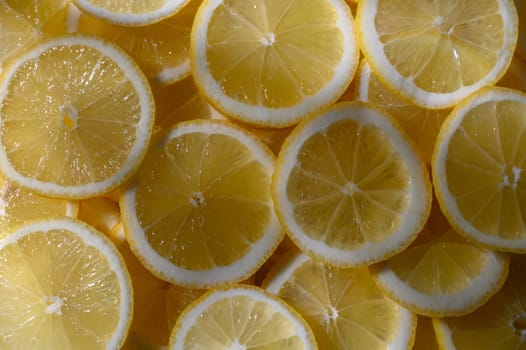 Citrusy, bright yellow lemon slices lay perfectly together, creating a refreshing and lively kitchen atmosphere.