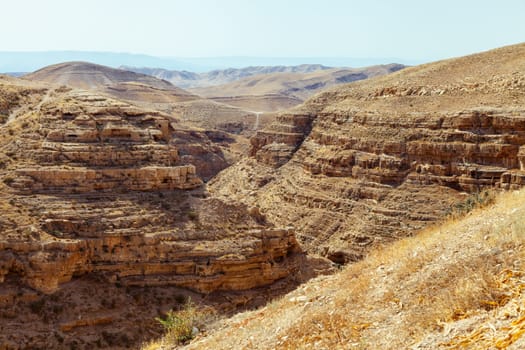 A breathtaking and stunning view of a vast desert canyon showcasing beautifully layered rock formations and dry terrain