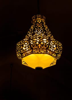 Traditional metal Morocco lantern with intricate pattern over black background
