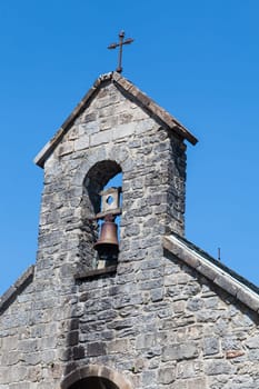 In the French Pyrenees, a charming stone chapel softly chimed, welcoming weary travelers on the Camino de Santiago.