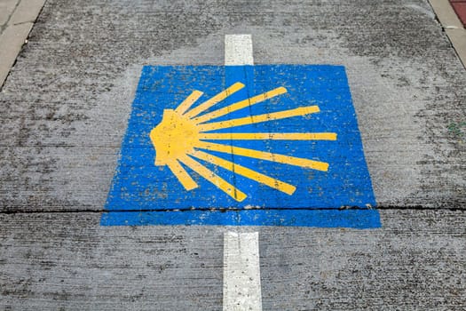 Symbol of pilgrimage route Camino de Santiago on a public pathway, inviting pilgrims and walkers.