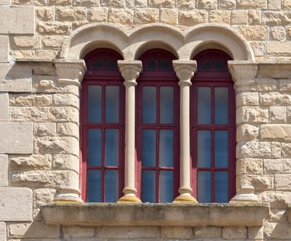An ornate stone window features columns and intricate designs, showcasing craftsmanship.