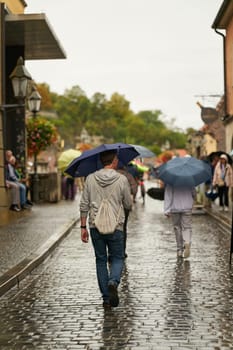 Wuerzburg, Germany – September 26, 2024: Tourists in rainy weather on the old Main Bridge, alte Mainbrücke in Wuerzburg