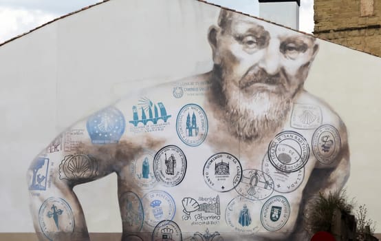 Logrono, SPAIN - May 25, 2016 - A detailed mural showcases a man adorned with various stamps representing the Camino de Santiago, emphasizing the essence of pilgrimage.