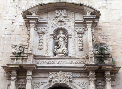 A beautifully detailed stone relief depicting a religious figure, framed by ornate architecture, captures attention.