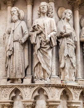 Intricate stone sculptures of religious figures enhance the architecture of the Burgos Cathedral, showcasing artistry.