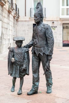 Two bronze statues depict a dancer child and tetin in Burgos, Spain, showcasing local artistry.