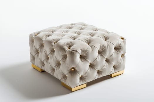 This stylish tufted ottoman features a neutral fabric and chic gold accents, ideal for enhancing contemporary interiors.
