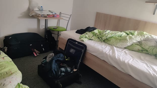 Messy suitcase bedroom house hotel apartment wooden bad travel tourism room indoor furniture. High quality photo. October 16 2024 Decin Czech Republic Europe travel places