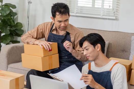 Two online entrepreneurs discuss package details while preparing for shipment, highlighting their teamwork and business acumen.
