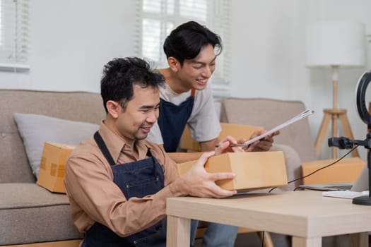 Two enthusiastic online sellers collaborate on packaging orders, highlighting their entrepreneurial spirit and teamwork.