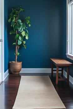 A serene entryway features a tall plant beside a wooden bench and a beige runner on dark hardwood flooring, accented by a blue wall.