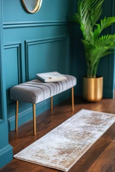 A contemporary entryway featuring a plush bench, a decorative rug, and a vibrant plant against a teal wall, creating an inviting atmosphere.